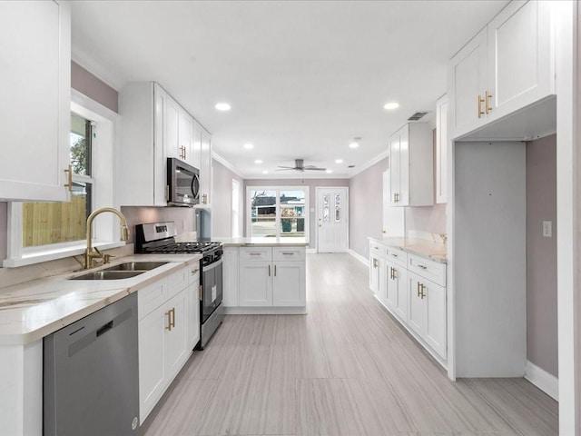 kitchen featuring stainless steel appliances, white cabinetry, sink, and ornamental molding