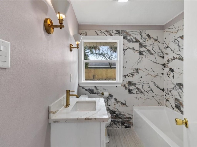 bathroom with vanity, ornamental molding, a washtub, and toilet