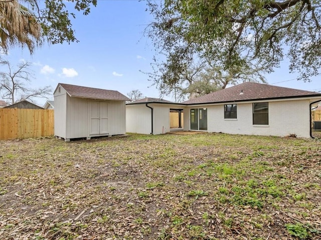 back of house featuring a storage unit