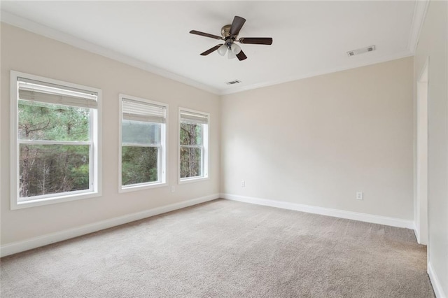 empty room featuring crown molding, ceiling fan, carpet flooring, and a wealth of natural light