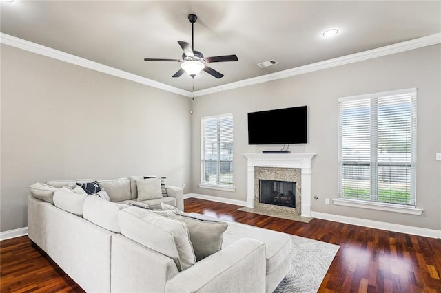 living room featuring ceiling fan, ornamental molding, a high end fireplace, and dark hardwood / wood-style flooring