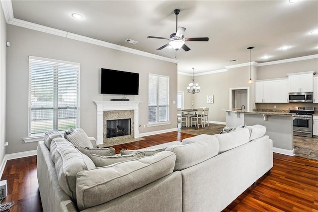 living room featuring crown molding, dark hardwood / wood-style floors, and ceiling fan with notable chandelier