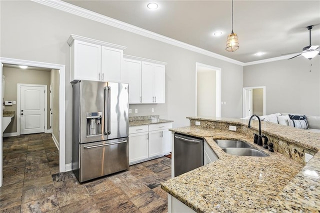 kitchen featuring pendant lighting, sink, crown molding, appliances with stainless steel finishes, and white cabinets