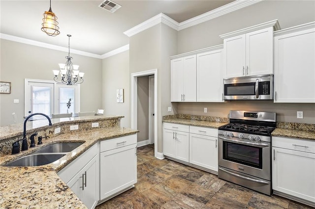 kitchen featuring white cabinetry, appliances with stainless steel finishes, sink, and pendant lighting