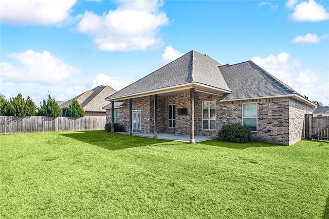 back of property with a patio area and a lawn