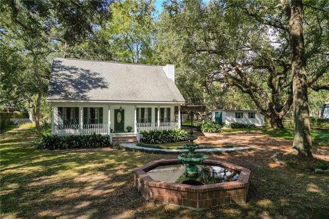 cape cod-style house featuring covered porch and a front yard