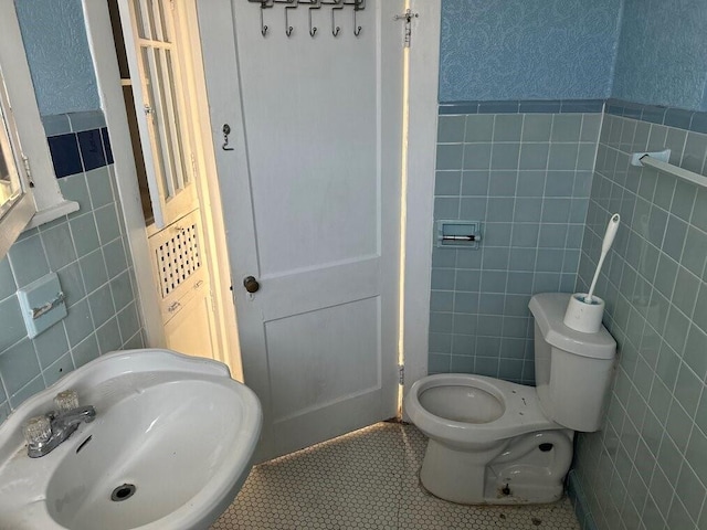 3526 Louisiana Ave Parkway, New Orleans, LA 70125 - bathroom featuring toilet, tile patterned flooring, sink, and tile walls