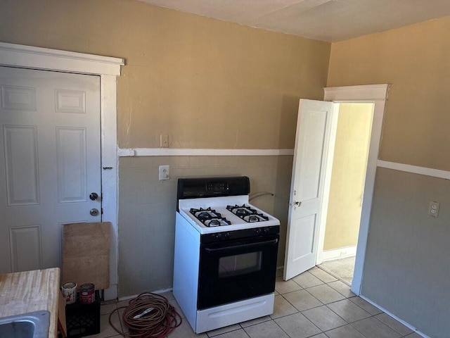 3526 Louisiana Ave Parkway, New Orleans, LA 70125 - kitchen with gas range, tile walls, and light tile patterned floors