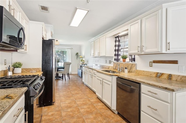 kitchen featuring sink, white cabinetry, light stone counters, light tile patterned floors, and appliances with stainless steel finishes