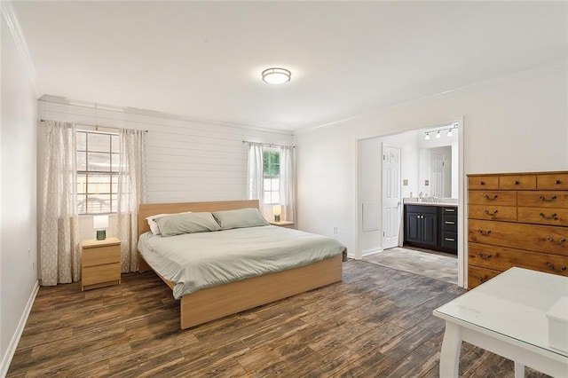 bedroom with dark hardwood / wood-style flooring, sink, crown molding, and ensuite bathroom