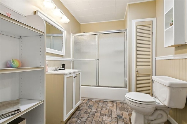 full bath featuring toilet, brick floor, enclosed tub / shower combo, and vanity