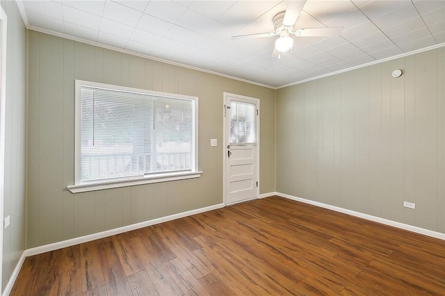 empty room featuring ornamental molding, ceiling fan, and wood finished floors