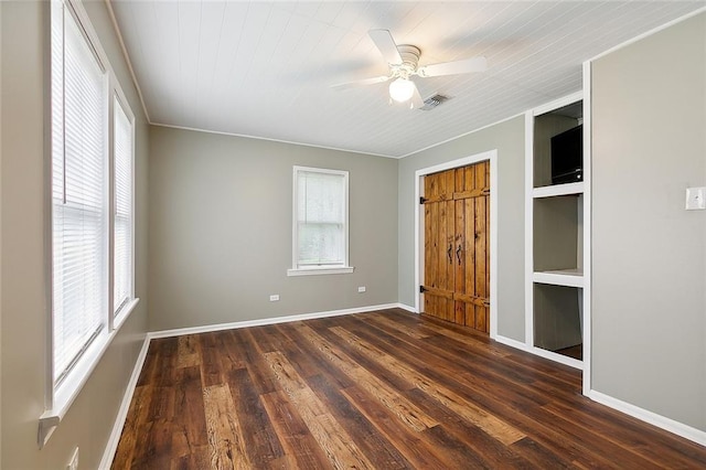 unfurnished bedroom featuring dark wood-style floors, ceiling fan, visible vents, and baseboards