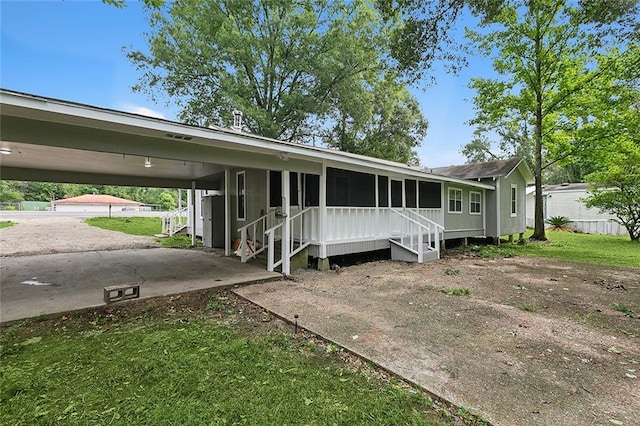 view of front of house featuring a sunroom and a carport