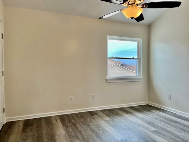 spare room featuring dark wood-type flooring and ceiling fan