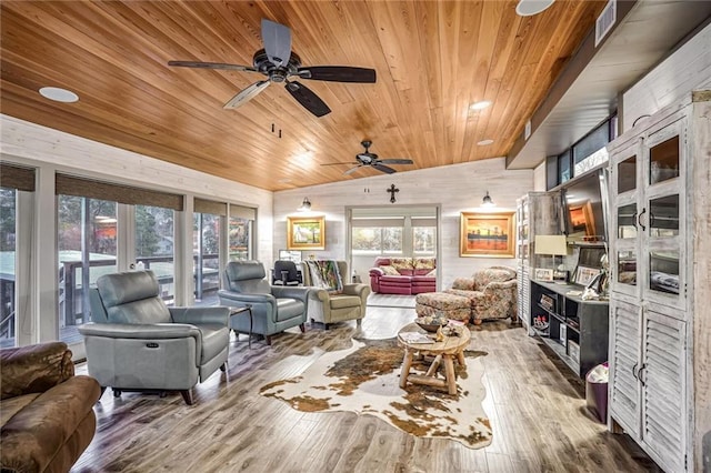 living room with visible vents, ceiling fan, wood finished floors, and wood ceiling