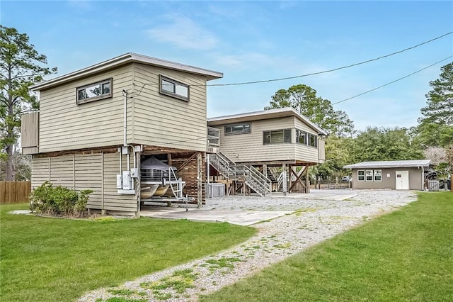 rear view of property with a patio, a yard, fence, and stairs