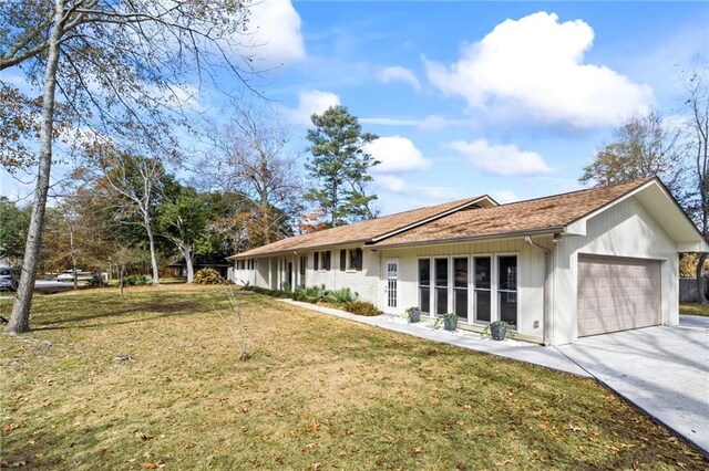 back of house with a garage and a yard