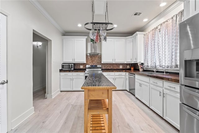 3845 Monroe St, Mandeville, LA 70448 - kitchen featuring decorative backsplash, stainless steel appliances, range hood, a sink, and crown molding