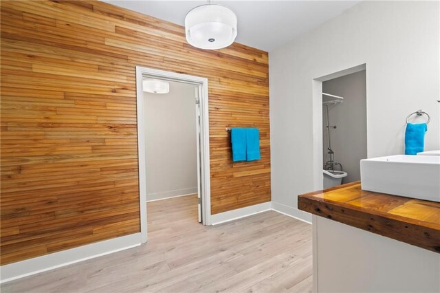 interior space featuring sink, wood-type flooring, and wood walls