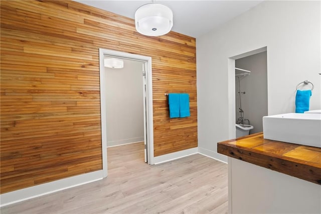 3845 Monroe St, Mandeville, LA 70448 - bathroom with a sink, a washtub, wood walls, baseboards, and wood finished floors