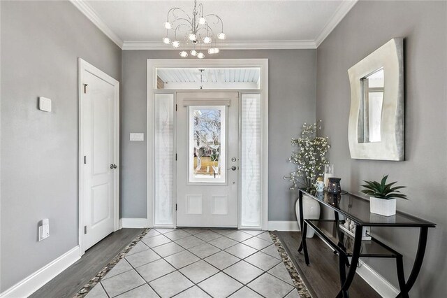 entryway with light tile patterned floors, crown molding, and a chandelier