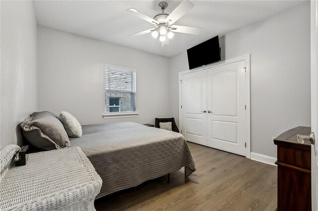 bedroom with hardwood / wood-style floors, a closet, and ceiling fan