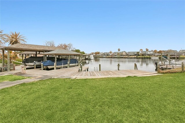 view of dock with a water view and a lawn