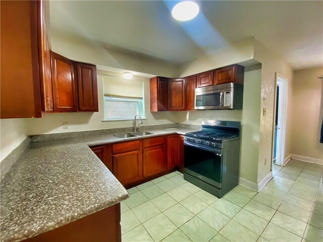 kitchen with light tile patterned flooring, sink, and gas stove