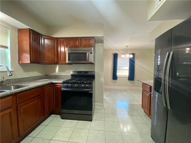 kitchen with refrigerator with ice dispenser, sink, light tile patterned floors, a notable chandelier, and gas range oven