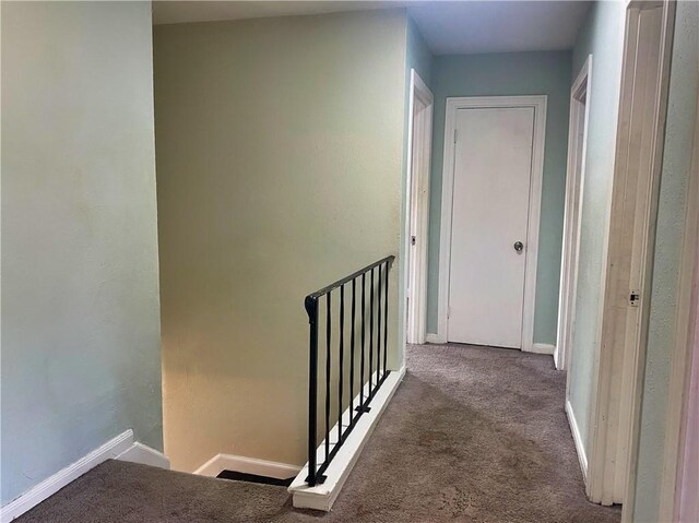 hallway featuring dark colored carpet