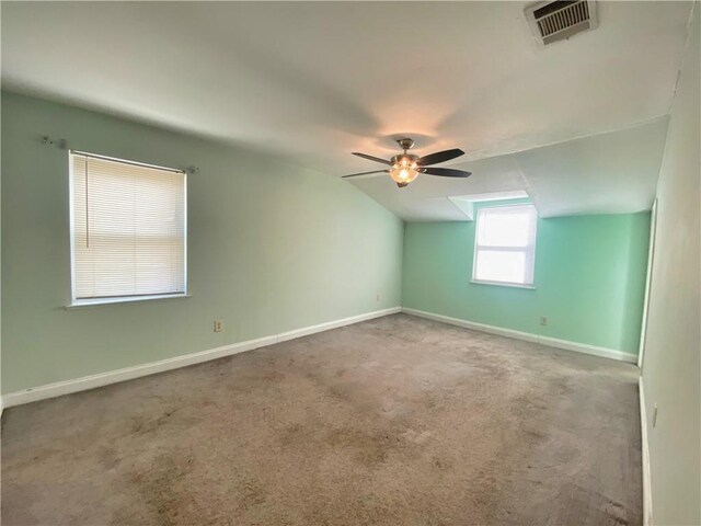 spare room featuring ceiling fan, carpet flooring, and vaulted ceiling