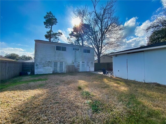 back of property with a yard and french doors