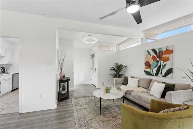 living room with sink, light hardwood / wood-style flooring, lofted ceiling with beams, and ceiling fan