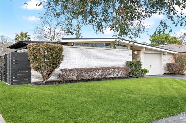 ranch-style house featuring a garage and a front lawn