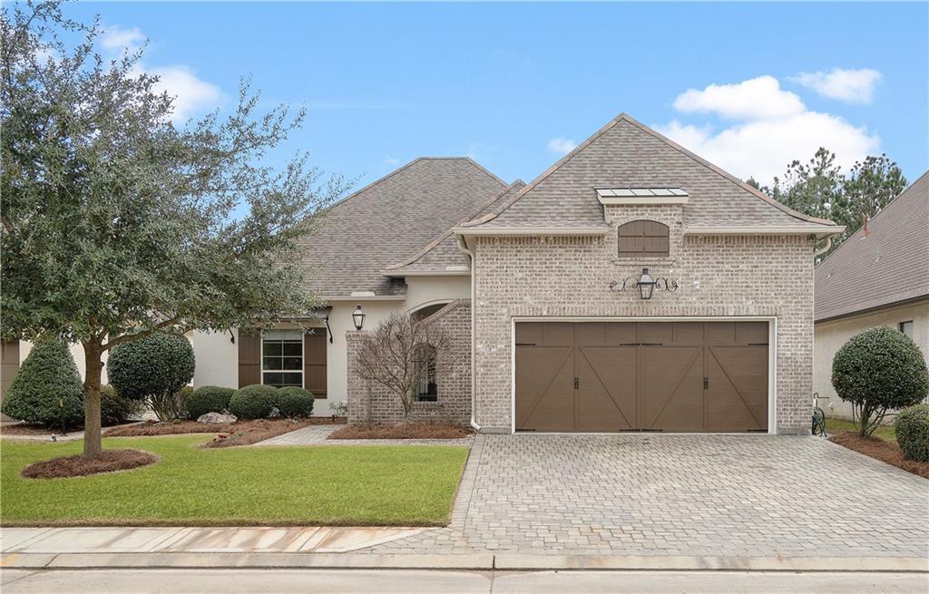 french country style house with a garage and a front yard