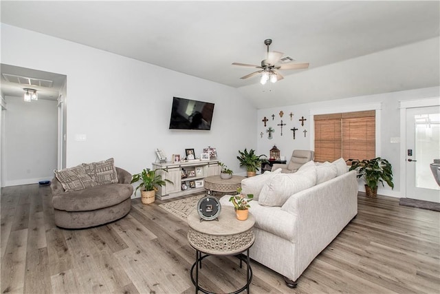 living room with lofted ceiling, hardwood / wood-style flooring, and ceiling fan