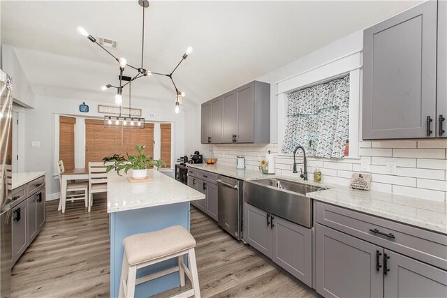 kitchen featuring sink, gray cabinets, dishwasher, a kitchen island, and pendant lighting