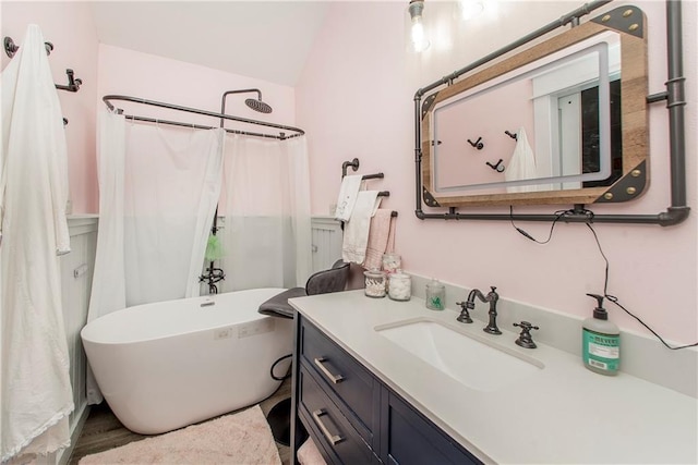 bathroom featuring vanity, a washtub, and lofted ceiling