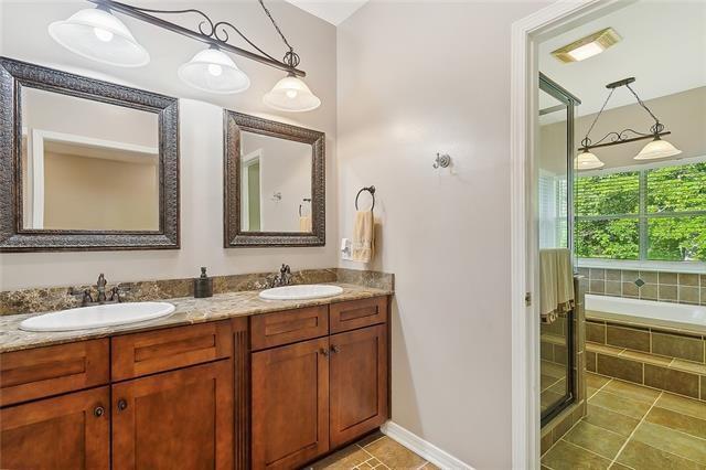 30302 Ashley Dr, Lacombe, LA 70445 - full bathroom with tile patterned floors, double vanity, tiled tub, and a sink