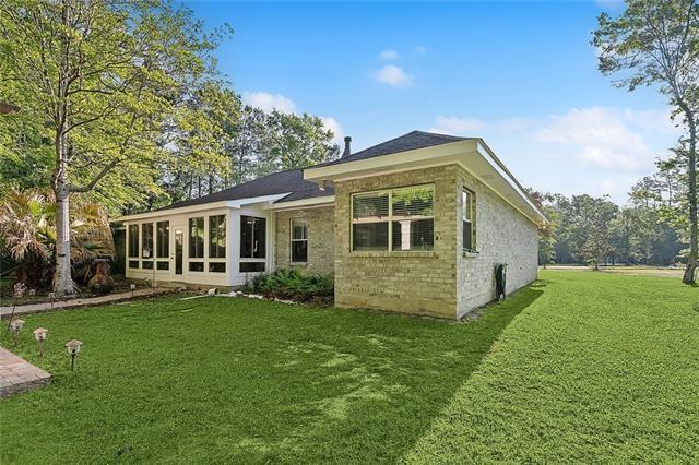 30302 Ashley Dr, Lacombe, LA 70445 - rear view of house with a yard, brick siding, and a sunroom