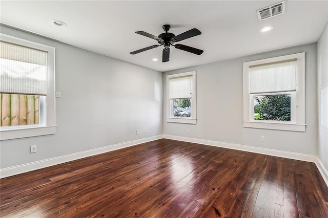 spare room with a wealth of natural light, dark hardwood / wood-style floors, and ceiling fan