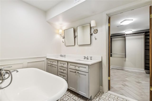 bathroom featuring vanity, parquet floors, and a bathing tub