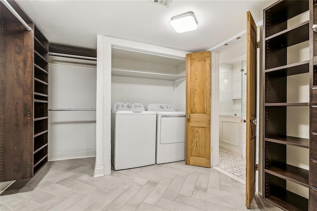 clothes washing area featuring separate washer and dryer and light parquet flooring