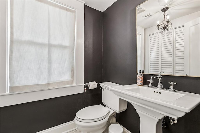 bathroom with an inviting chandelier, sink, and toilet