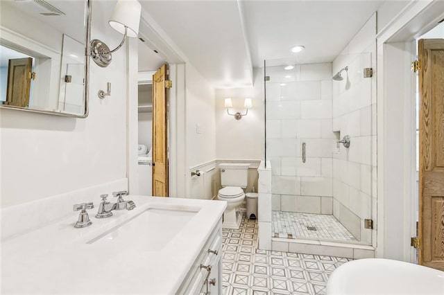 bathroom with toilet, vanity, tile patterned floors, and walk in shower