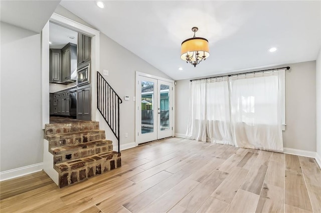 interior space with lofted ceiling, a notable chandelier, and light hardwood / wood-style flooring