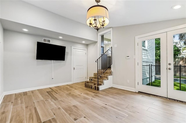 interior space with french doors, an inviting chandelier, and light hardwood / wood-style flooring