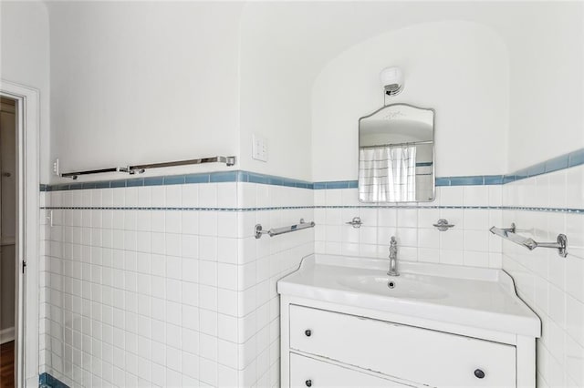 bathroom with vanity and tile walls