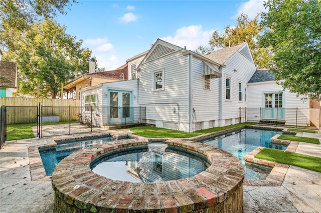 back of house with a patio and a pool with hot tub